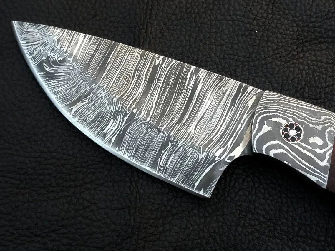Damascus steel hunting knife on black surface