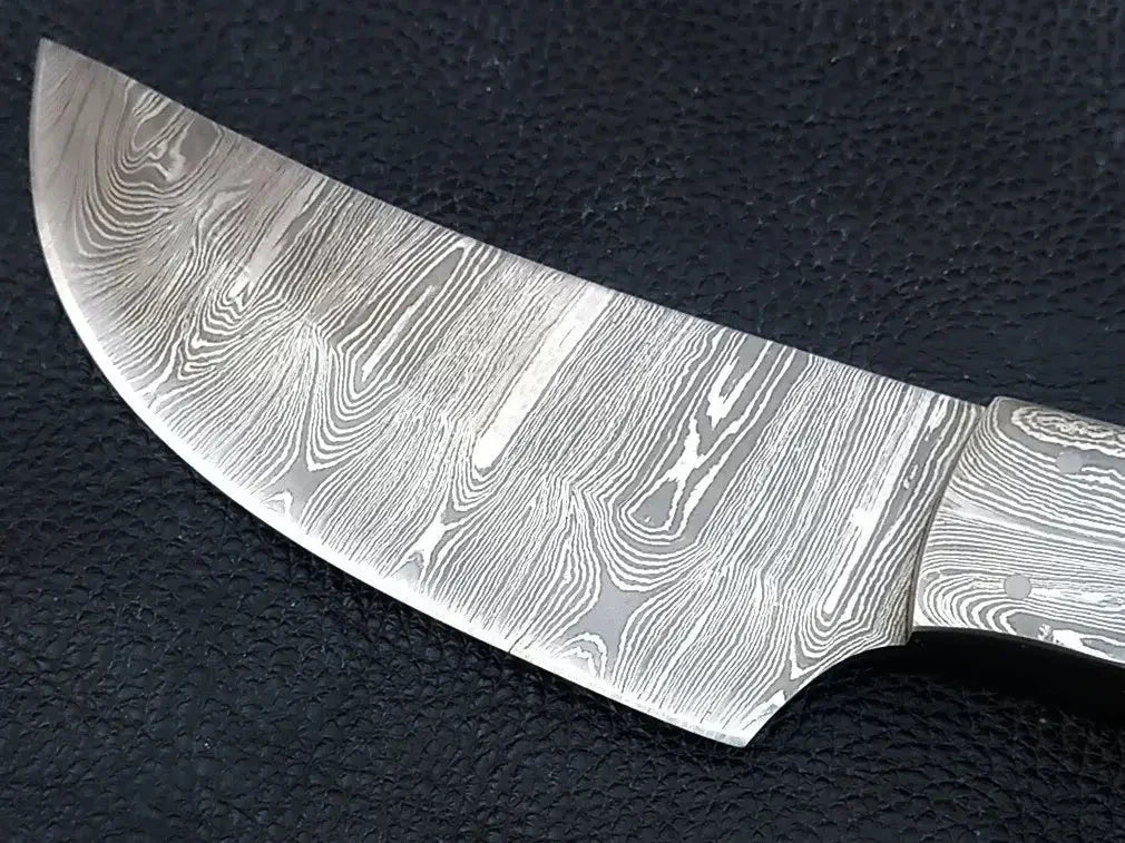 Handmade Damascus steel knife on black surface