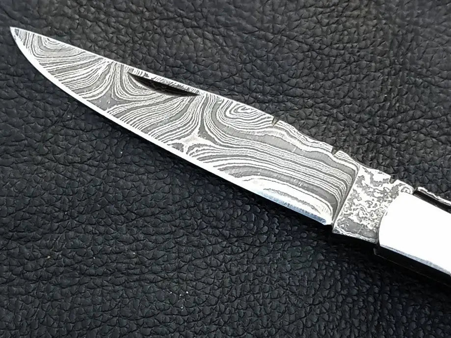 Handmade Damascus Steel Folding Knife -C163 on leather surface